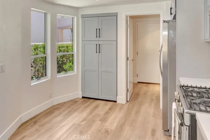Eating area in kitchen looks out onto lush green space.