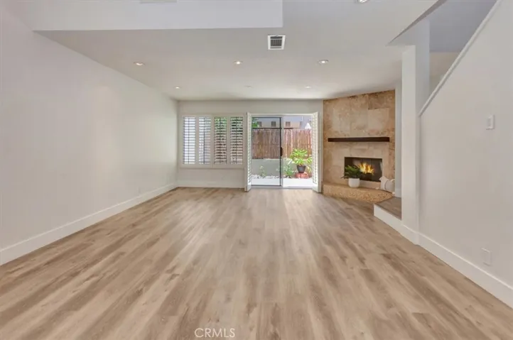 Living Room with LVP flooring, corner fireplace, high ceilings & skylights.