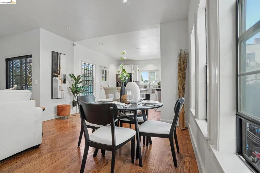Dining area featuring wood-finish flooring, recessed lighting, and a window bank with white trim