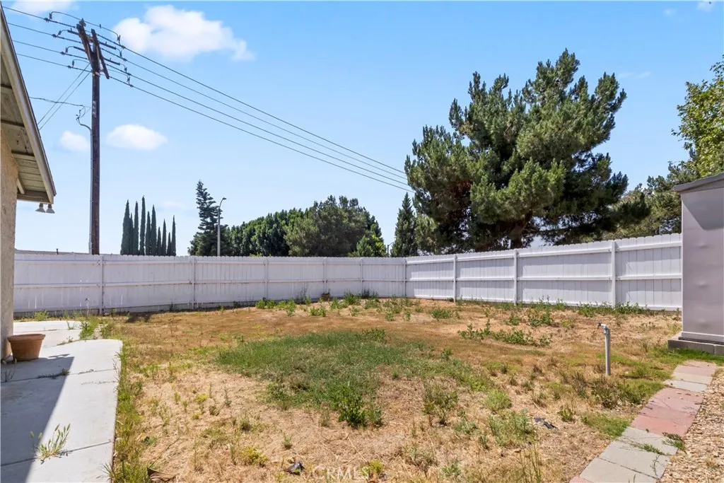 Rear exterior with spacious lot, mature trees, and park adjacency