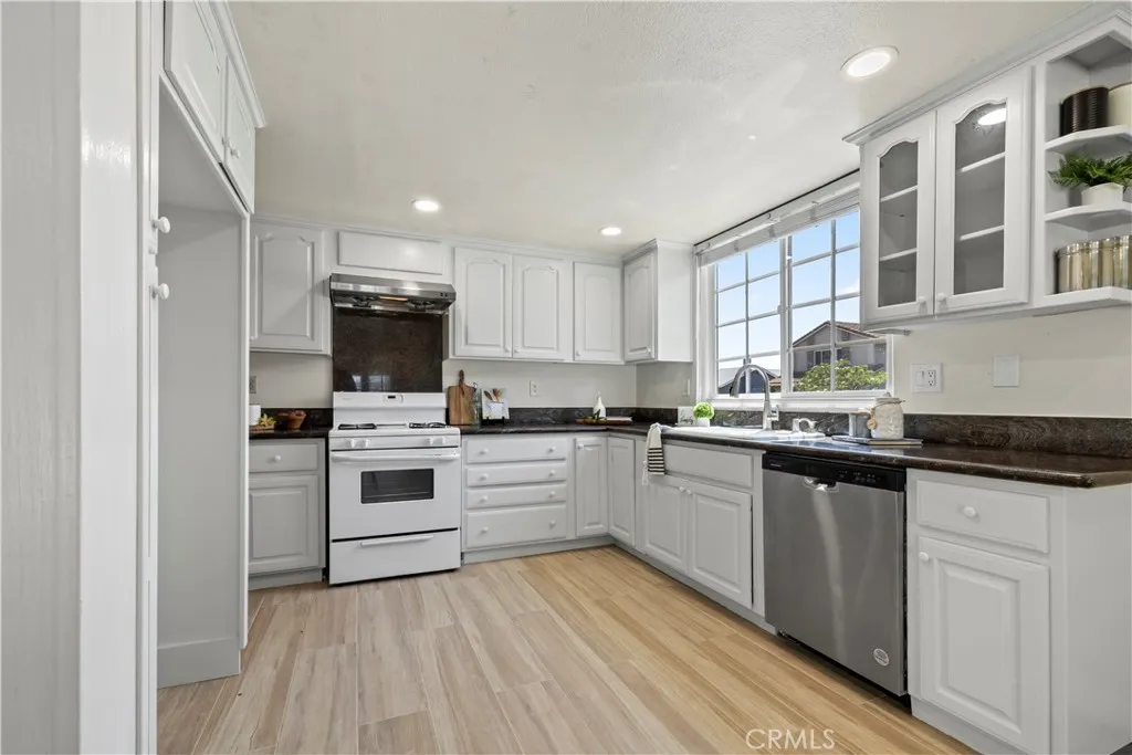 Updated kitchen with white cabinets and appliances