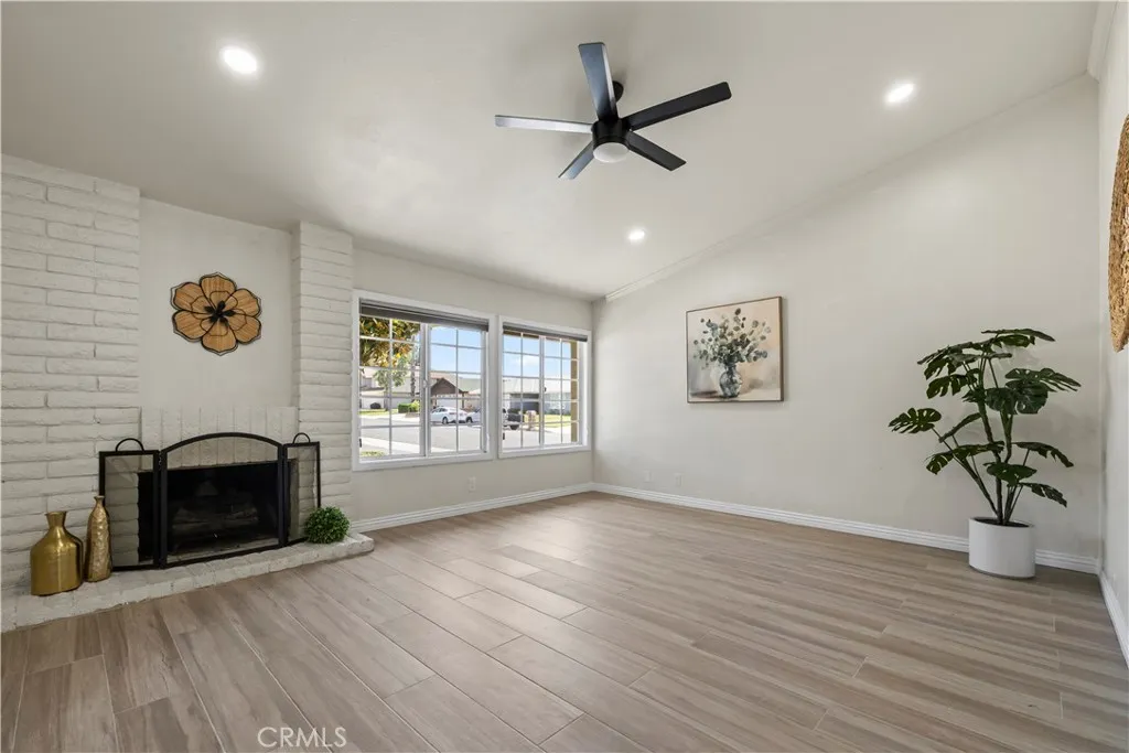 Airy living area with soaring ceilings, ceiling fan, and large windows