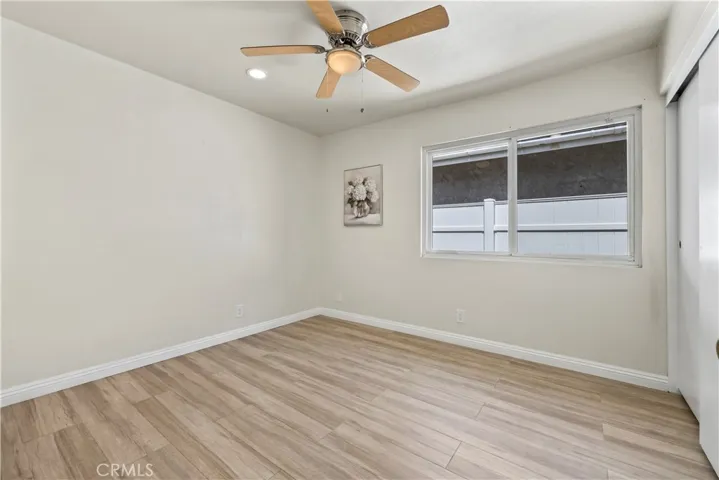 Bright bedroom with ceiling fan and large windows