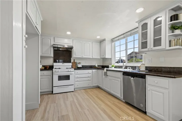 Updated kitchen with white cabinets and appliances