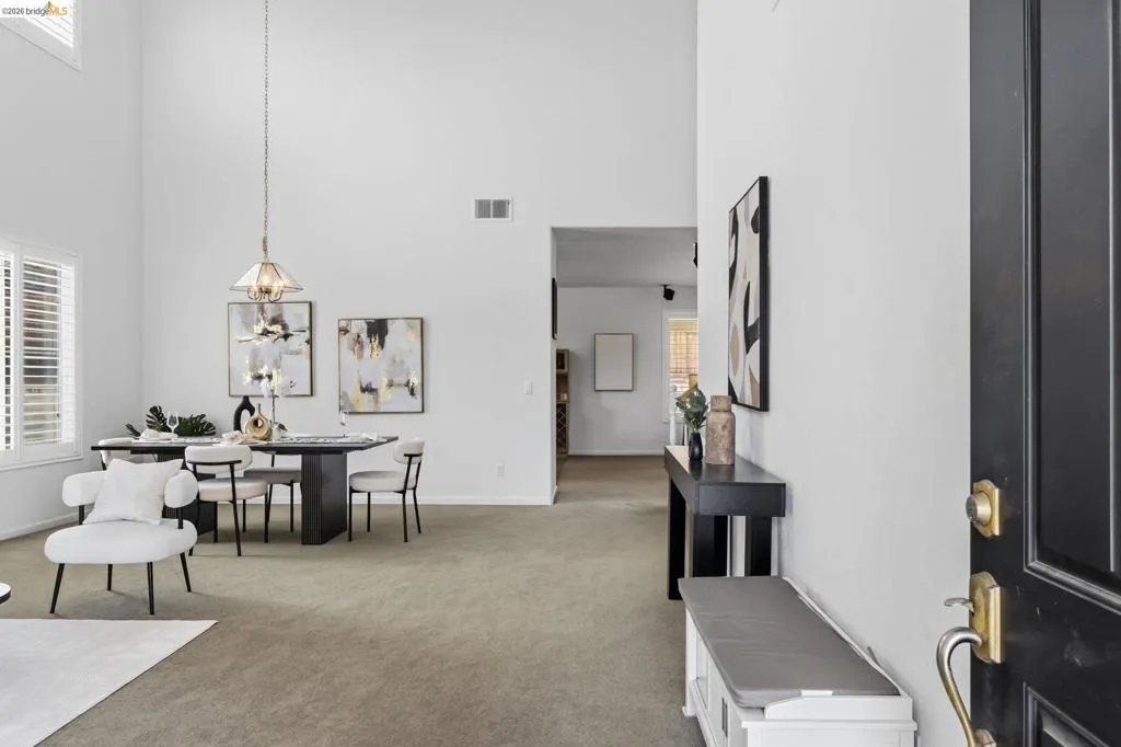 Entryway with high ceilings and light-toned carpeting throughout