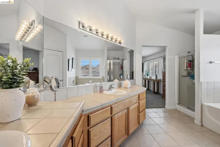 Double vanity with tile countertops and wood cabinetry
