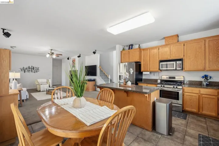 Kitchen featuring wood cabinetry, stainless steel appliances, and granite-look countertops