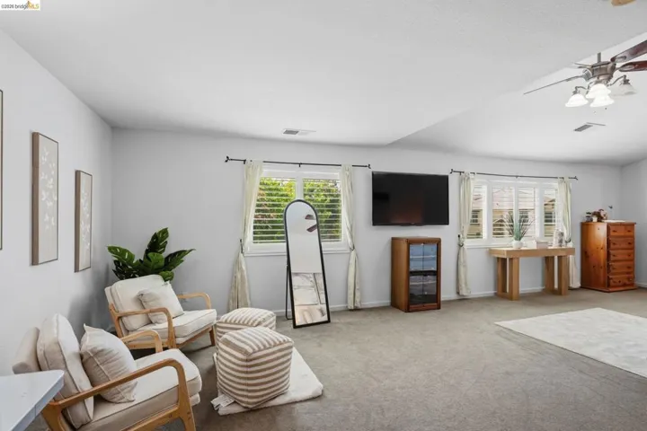 Spacious room featuring light gray wall paint and gray carpeting