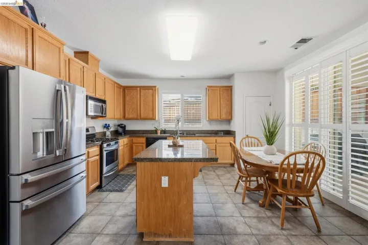 Kitchen featuring light wood cabinetry, granite countertops, and stainless steel appliances