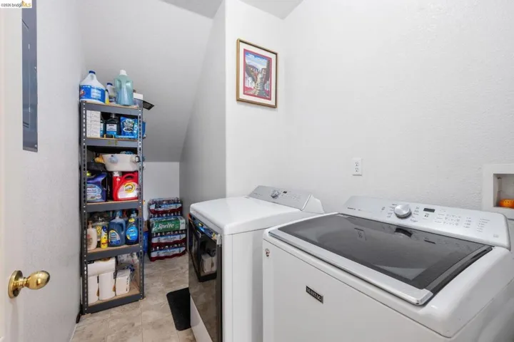 Dedicated laundry space featuring a white top-load washer and a front-load dryer