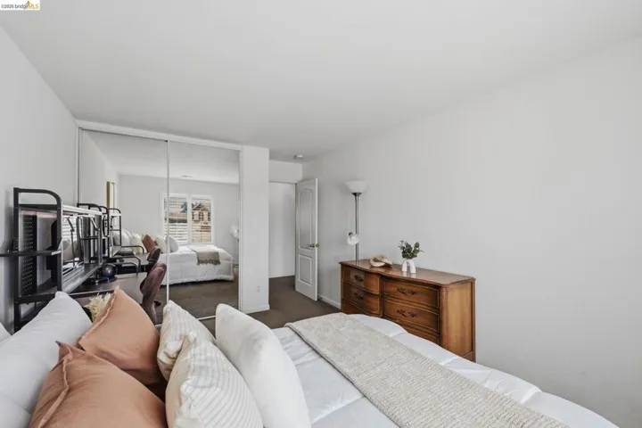 Bedroom featuring a full mirrored closet, neutral wall tones, and dark tone carpeting
