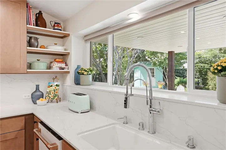 From the kitchen sink, you can look over the covered patio straight towards the bird bath with its year-round visitors. New windows and custom window covers throughout.