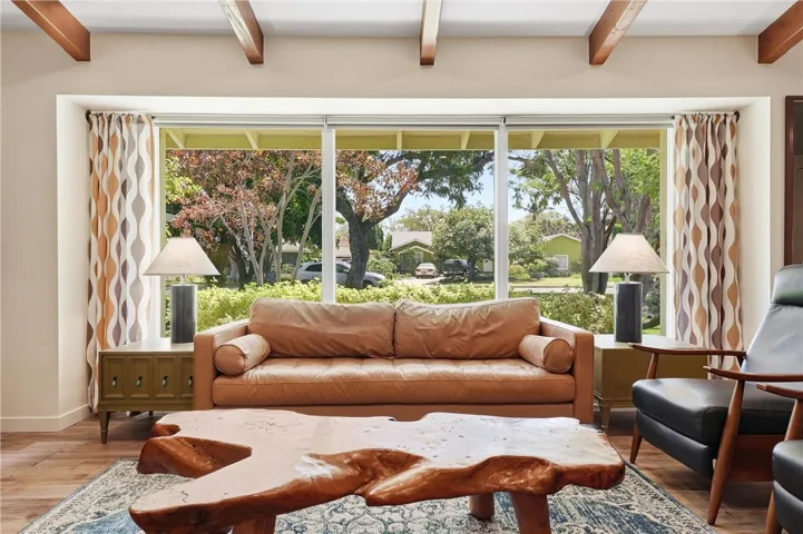 Oversized windows bring the light and greenery inside the living room.