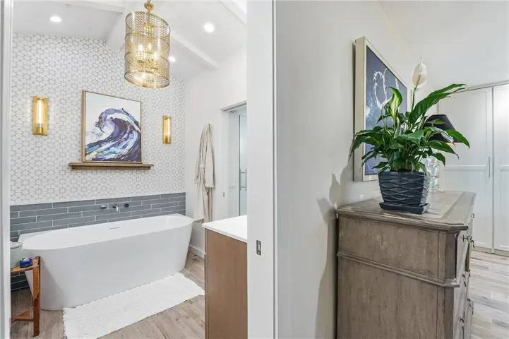 What touches! The primary en suite bathroom has a soaking tub, walk-in shower, pocket door, designer tiles and lighting, two separate sinks, and details like a deep medicine cabinet with an outlet for your appliances.