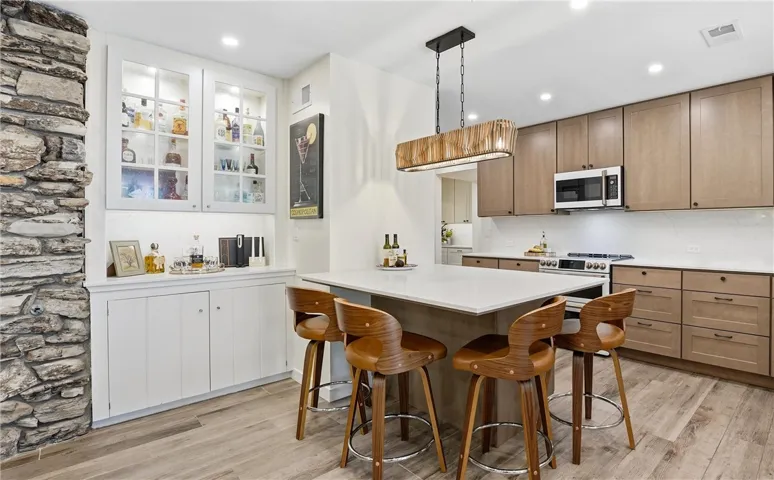 So many great functional details in this home with its coffee or drink bar, deep peninsula that comfortably seats long legs, and an updated kitchen with wood pull out cabinet drawers.