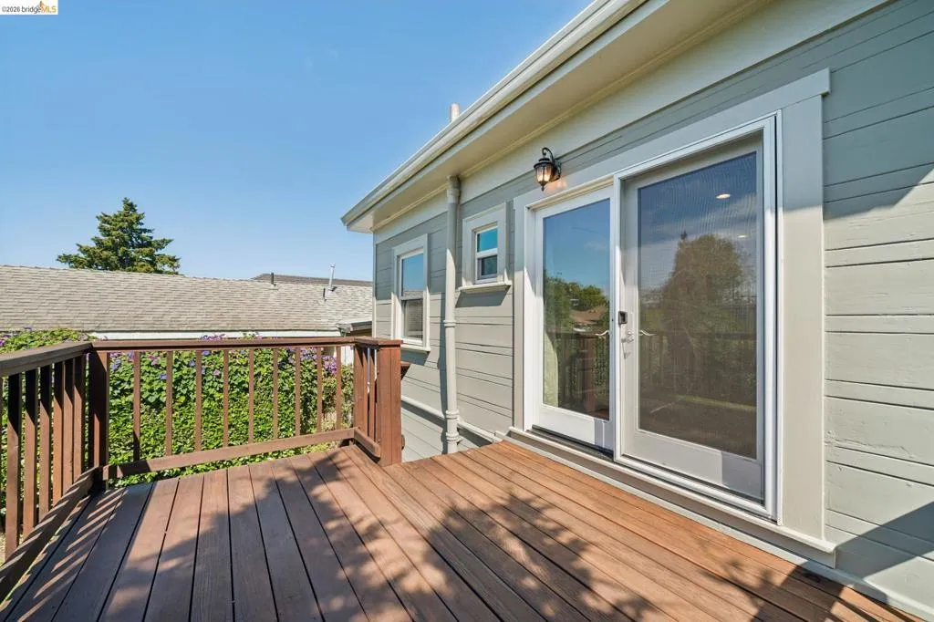 Outdoor deck featuring rich wood-finish planks and a coordinating wood railing