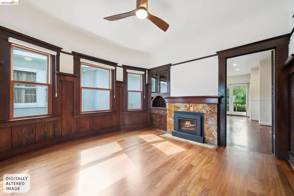 Spacious room with wood-finish flooring, dark wood wainscoting, and white upper walls