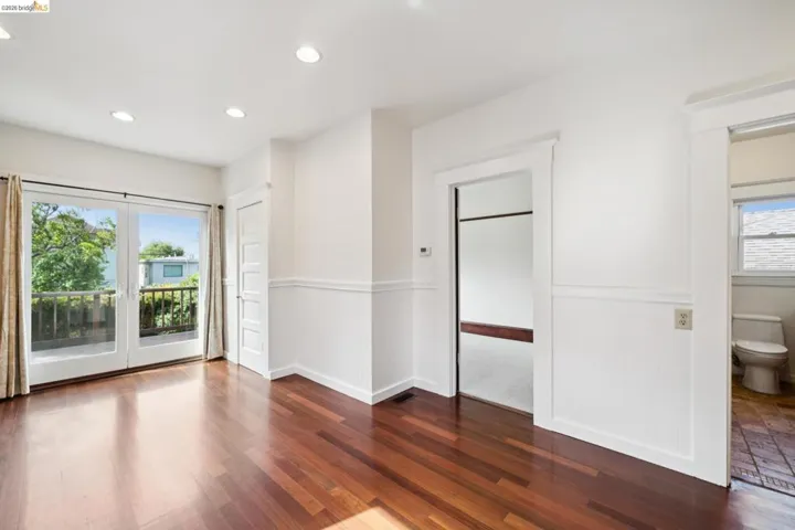 Wood-finish flooring throughout, complemented by white walls with wainscoting