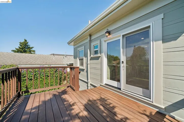 Outdoor deck featuring rich wood-finish planks and a coordinating wood railing