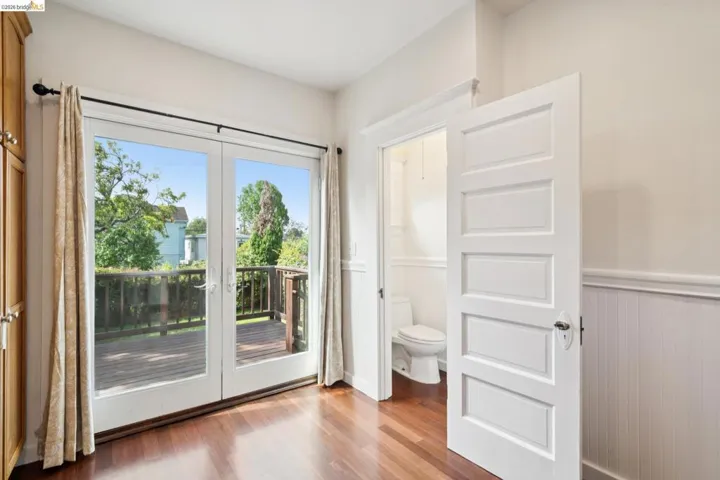 Double glass doors open to an outdoor wood-finish deck