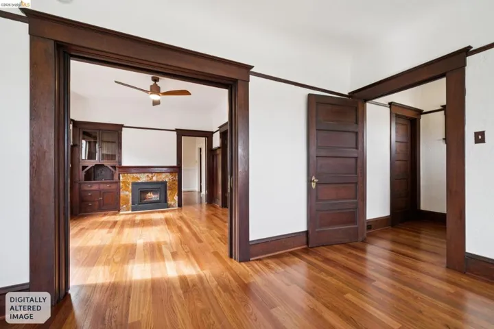 Hardwood flooring throughout featuring dark wood trim and panel doors