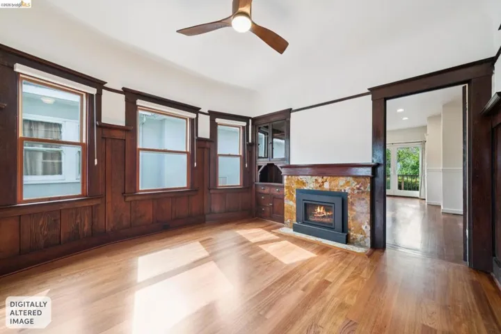 Spacious room with wood-finish flooring, dark wood wainscoting, and white upper walls