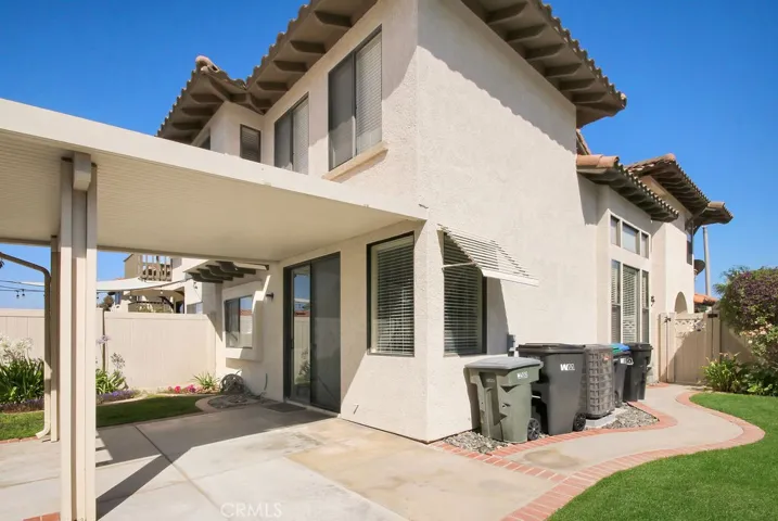 This well-maintained backyard features a covered patio, grassy play area, and low-maintenance landscaping.