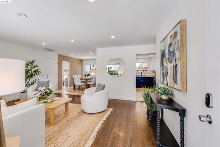 Open concept living area featuring dark wood-finish flooring, recessed lighting, and a white interior door
