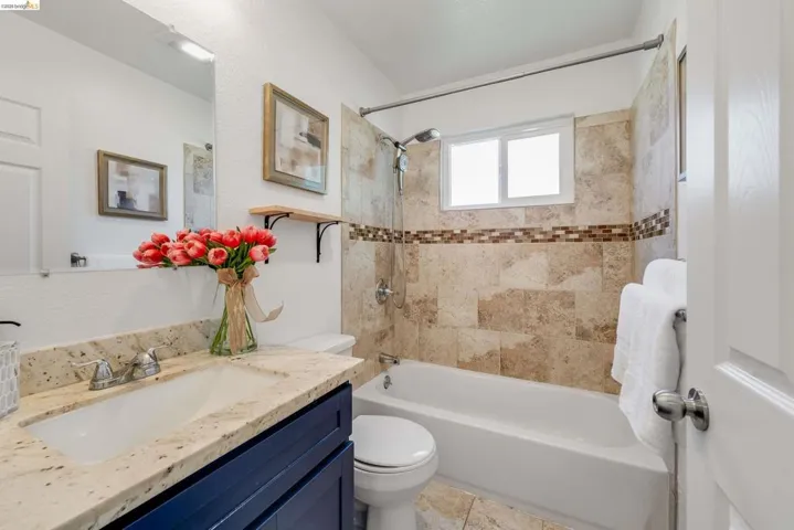 Bathroom featuring a vanity with an integrated sink, a speckled countertop, and a dark blue base cabinetry