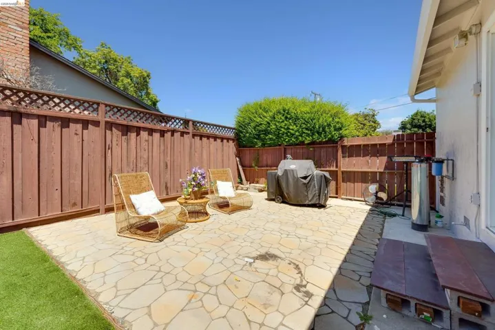 Expansive flagstone patio with a perimeter privacy fence featuring lattice detailing