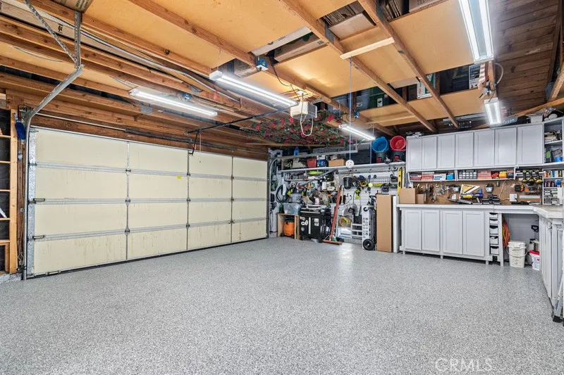 Garage with epoxy flooring, workspaces and cabinetry