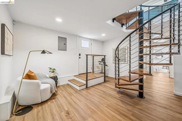 Modern spiral staircase featuring wood-finish treads and metal railing