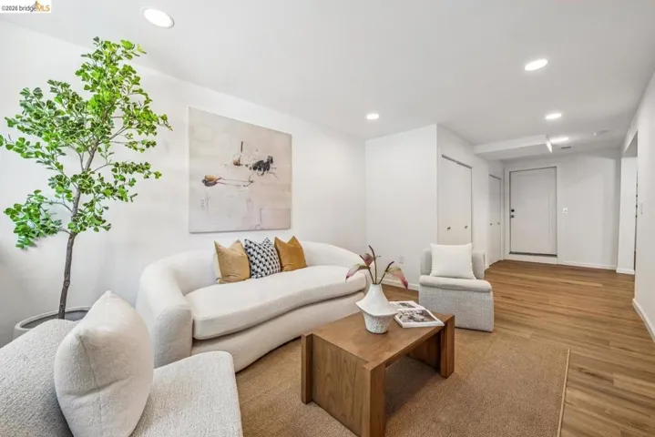 Open living space featuring recessed lighting, hardwood floors, and laundry closet.