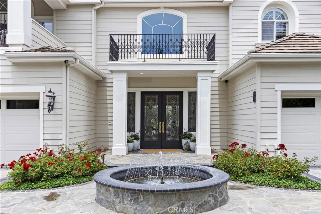 Elegant private entryway features a tranquil fountain and landscaped gardens, creating an inviting first impression.