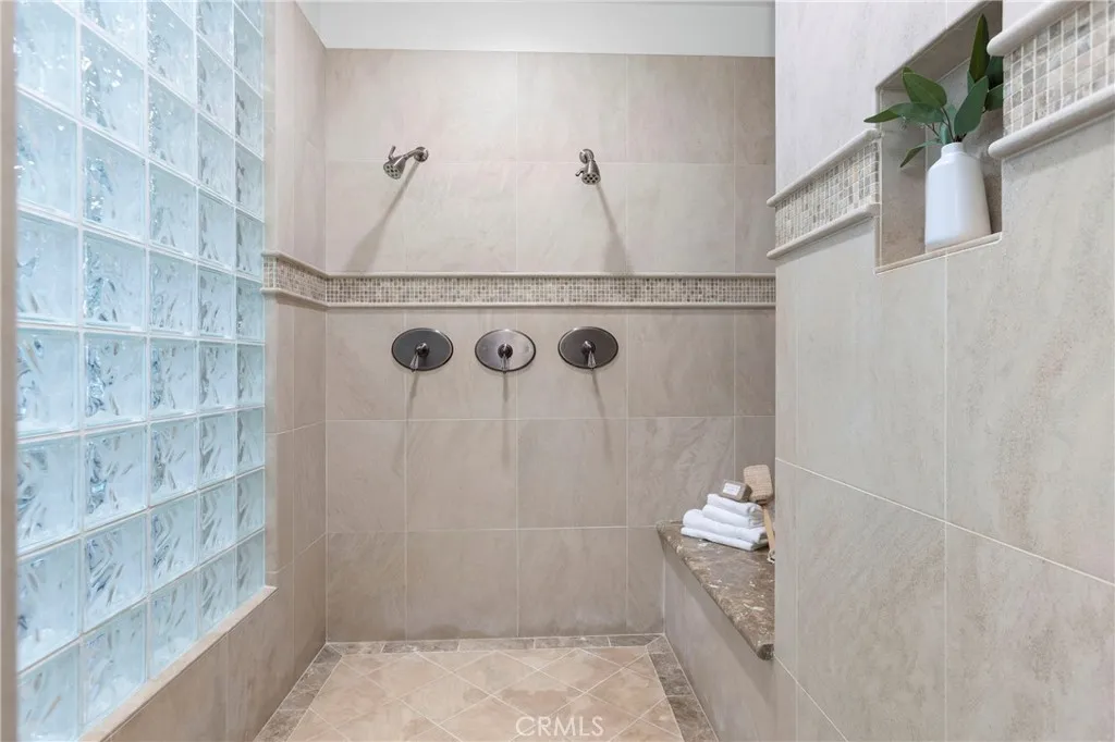 Primary Bathroom-Discover a spacious walk-in shower featuring dual showerheads and modern finishes, perfect for daily relaxation.
