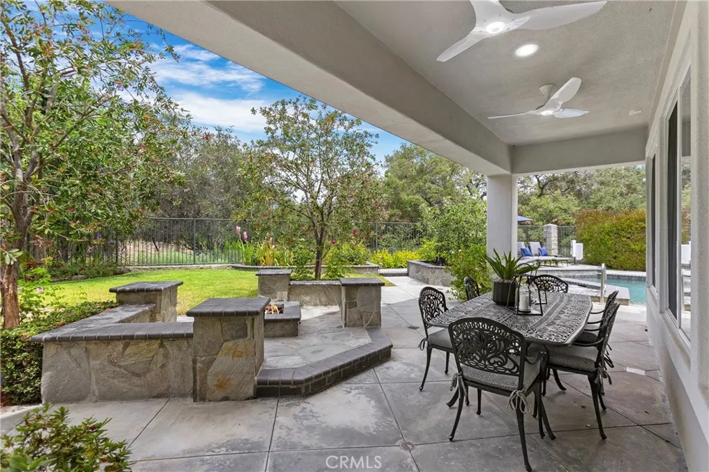 Spacious outdoor patio features a built-in firepit, ceiling fans and lighting perfect for gatherings and enjoying nature.