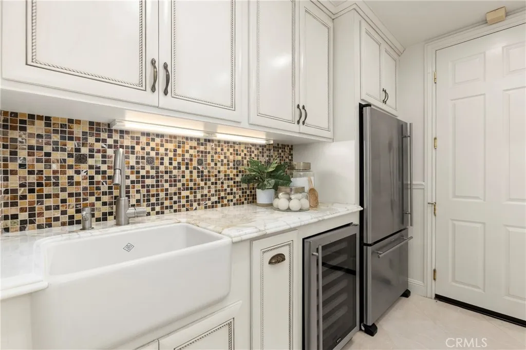 Modern Laundry room  featuring a unique mosaic backsplash, spacious sink, and upgraded stainless steel appliances (Fridge and Wine Fridge included)