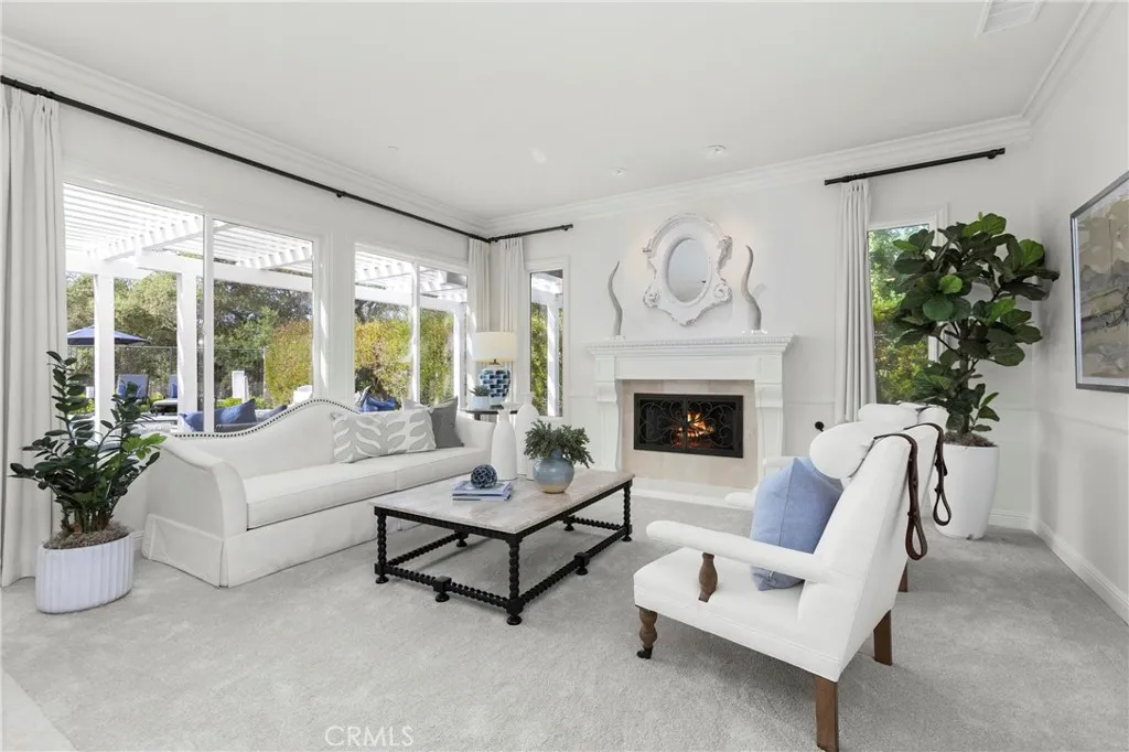  inviting living room featuring a cozy fireplace and large windows for abundant natural light.