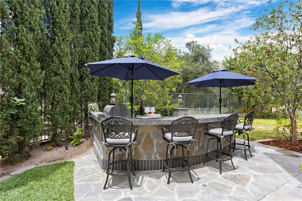 Discover a spacious outdoor bar area with ample seating and shade for relaxing gatherings.