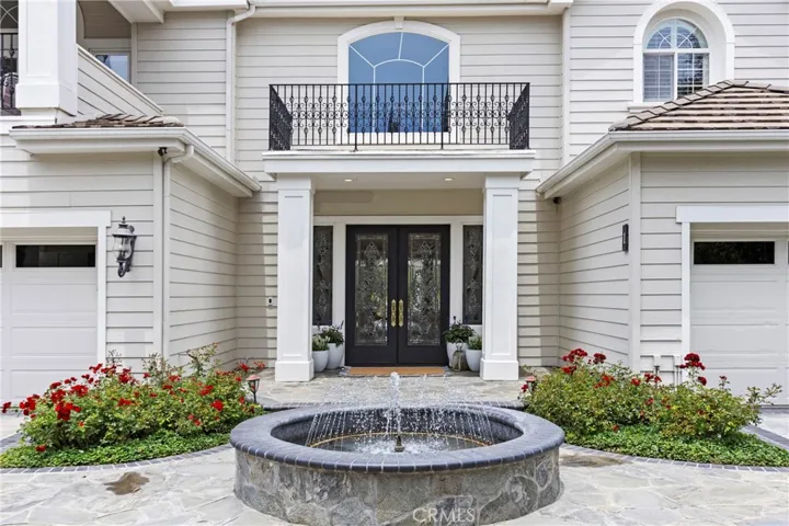 Elegant private entryway features a tranquil fountain and landscaped gardens, creating an inviting first impression.