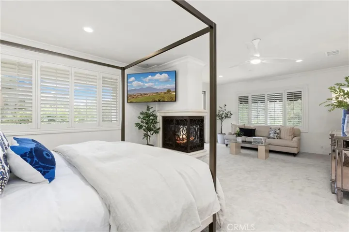 Primary Bedroom -Spacious bedroom with a cozy fireplace, adjacent sitting area, and abundant natural light throughout. (TV Included)