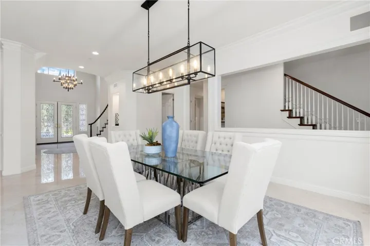 Bright and airy dining area, featuring a modern glass table and plush seating, perfect for gatherings.