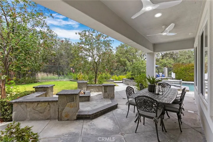 Spacious outdoor patio features a built-in firepit, ceiling fans and lighting perfect for gatherings and enjoying nature.