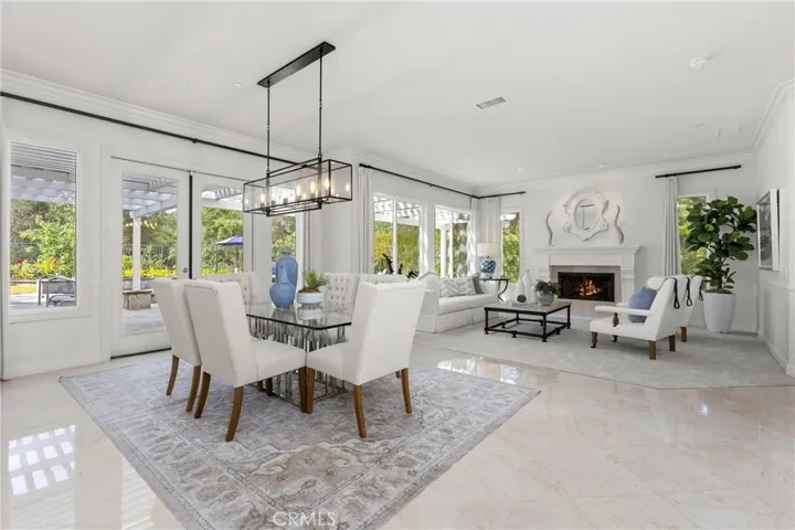 Bright and spacious living area with large windows, a cozy fireplace, and a seamless outdoor connection.