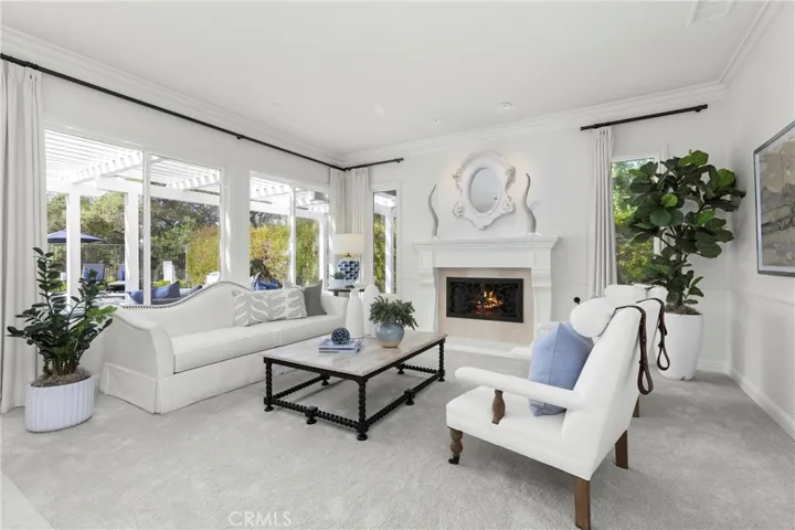  inviting living room featuring a cozy fireplace and large windows for abundant natural light.