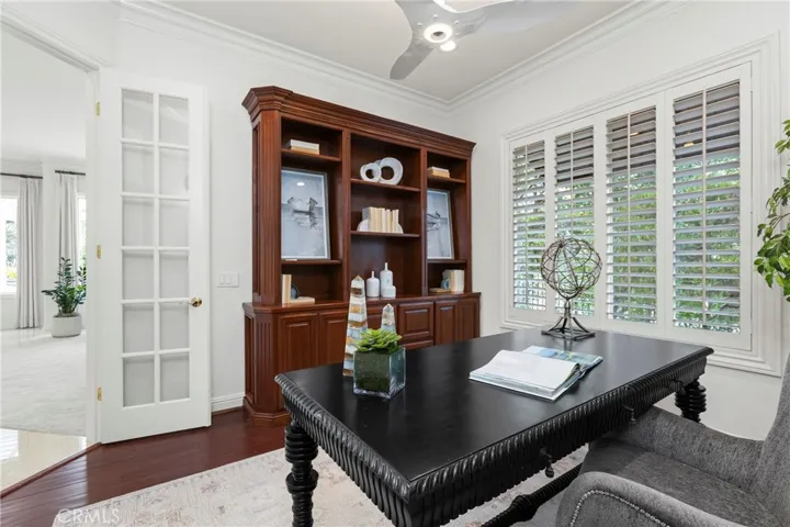 Home office featuring built-in shelving, large windows, and modern lighting for productivity.