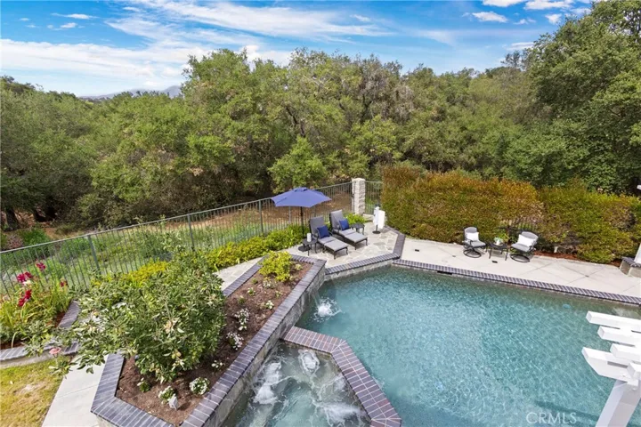 Primary Bedroom Balcony -Discover a private oasis with a refreshing pool, lush greenery, and inviting outdoor seating for relaxation.