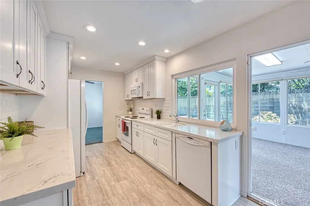 Professional kitchen featuring elegant quartz countertops, custom cabinetry, and generous storage space throughout.