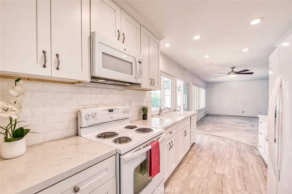 Remodeled kitchen featuring elegant quartz countertops, custom cabinetry, and generous storage space opens to the family room.
