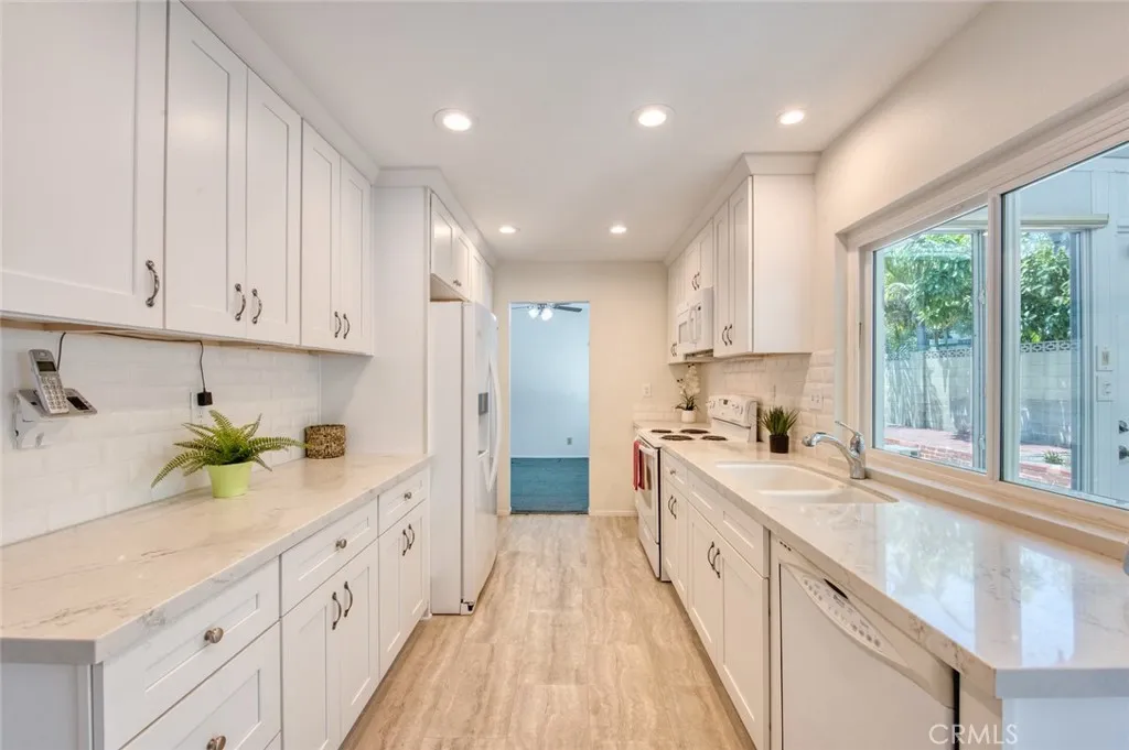 Professional kitchen featuring elegant quartz countertops, custom cabinetry, and generous storage space throughout.
